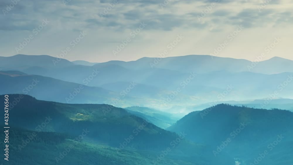 Sunbeams and Clouds Over Wooded Mountains. Fast Motion