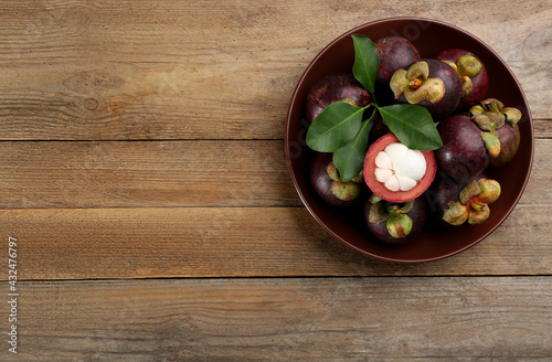 Delicious tropical mangosteens on wooden table, top view. Space for text