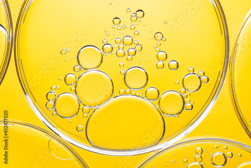 Beautiful macro photo of water droplets in oil with a yellow background. Abstract art