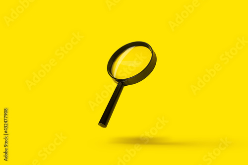 magnifying glass loupe magnifier search flies soars over yellow background