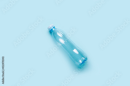 empty plastic bottle on a blue background. Top view, copy space
