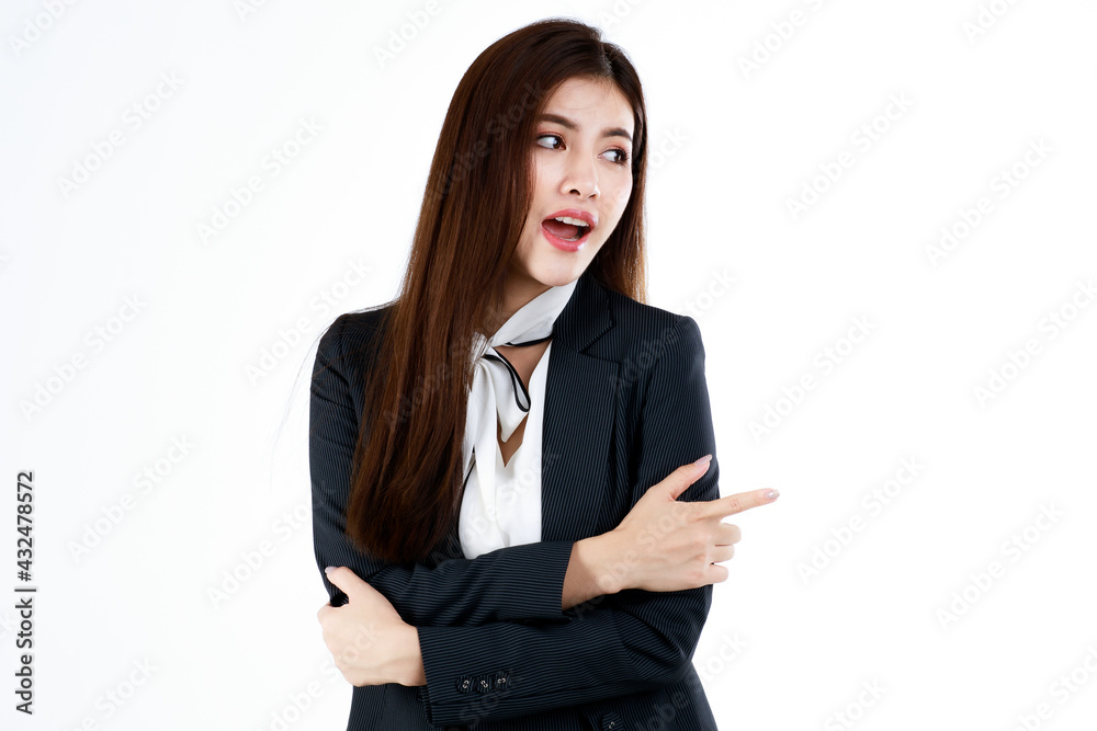 Portrait of young Asian businesswoman in formal suit posing and pointing finger to blank space for present or demonstrate goods or product in advertising gesture, studio shot on white background Portrait of young Asian businesswoman in formal suit posing and pointing finger to blank space for present or demonstrate goods or product in advertising gesture, studio shot on white background