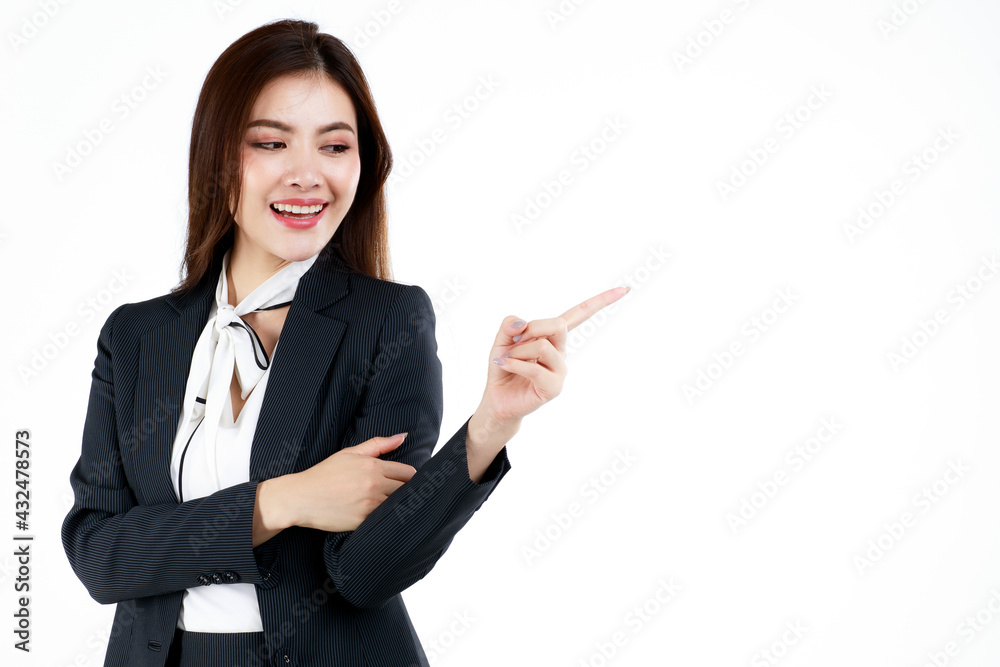 Portrait of young Asian businesswoman in formal suit posing and pointing finger to blank space for present or demonstrate goods or product in advertising gesture, studio shot on white background Portrait of young Asian businesswoman in formal suit posing and pointing finger to blank space for present or demonstrate goods or product in advertising gesture, studio shot on white background