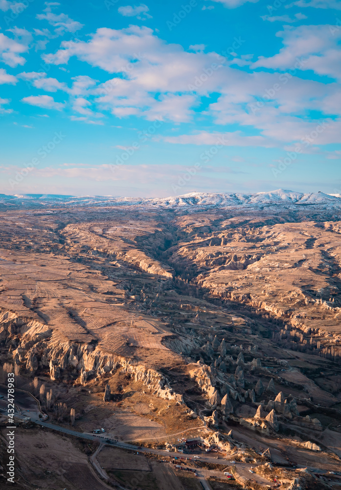 Beautiful vertical aerial view of the landscapes of Cappadocia, Turkey with fairy chimneys, mountains, rock formations and the town of Ürgüp