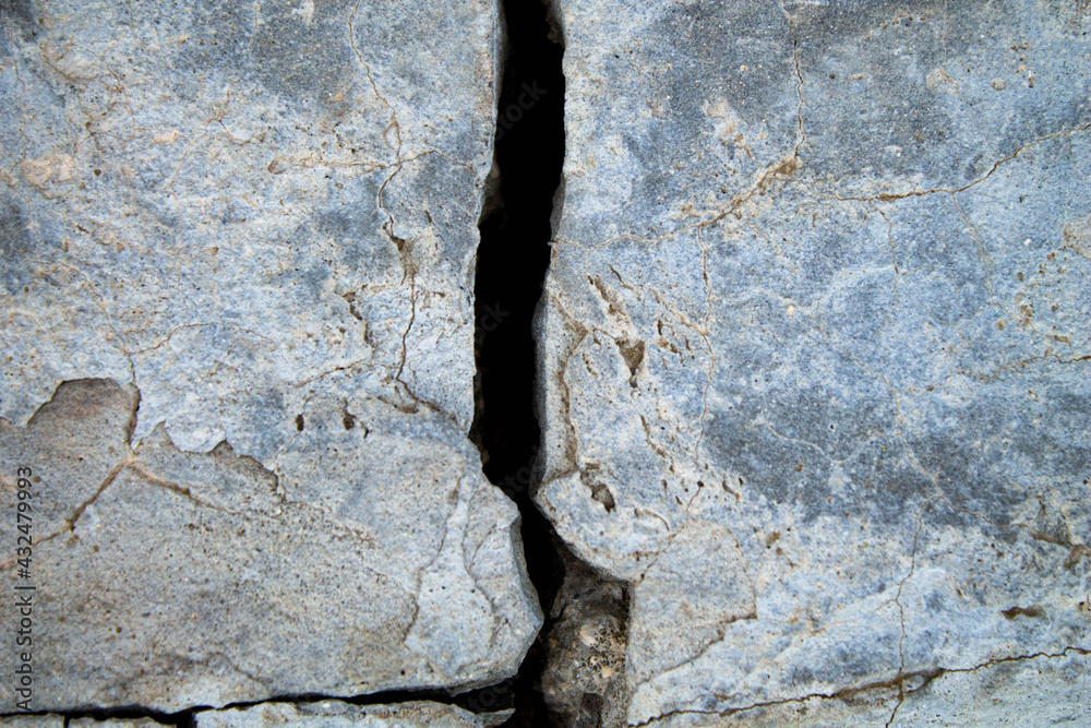 Broken wall with cracks. The gray plaster fell off the wall. Broken wall with cracks. The gray plaster fell off the wall.