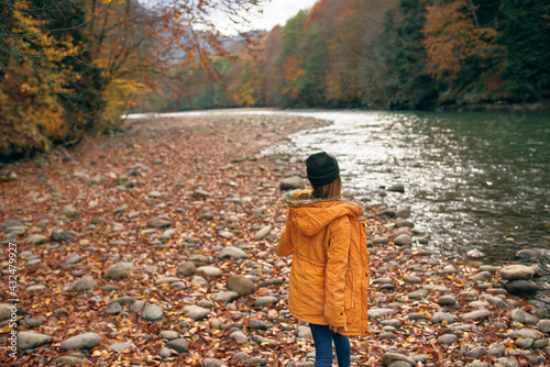 woman walking in the forest along the river autumn travel © SHOTPRIME STUDIO