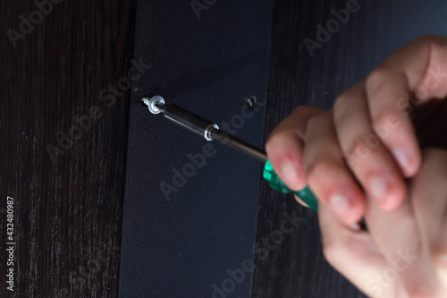 Male hands assembling furniture closeup