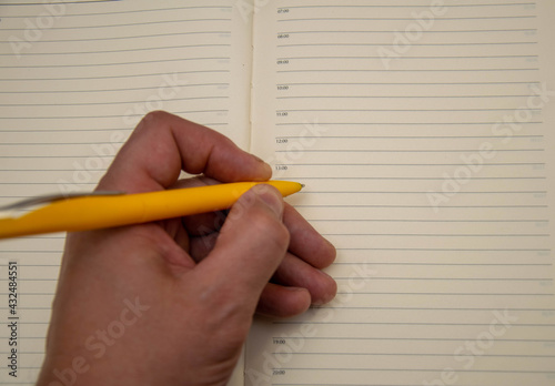 Pen in hand on the background of the diary.
