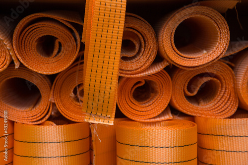 Industrial sewing machine sews a webbing sling. Manufacture of textile slings and tie straps.