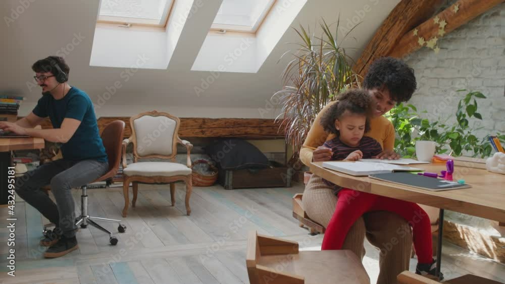 Mother and daughter learning while the father works. Mother and daughter learning while the father works.