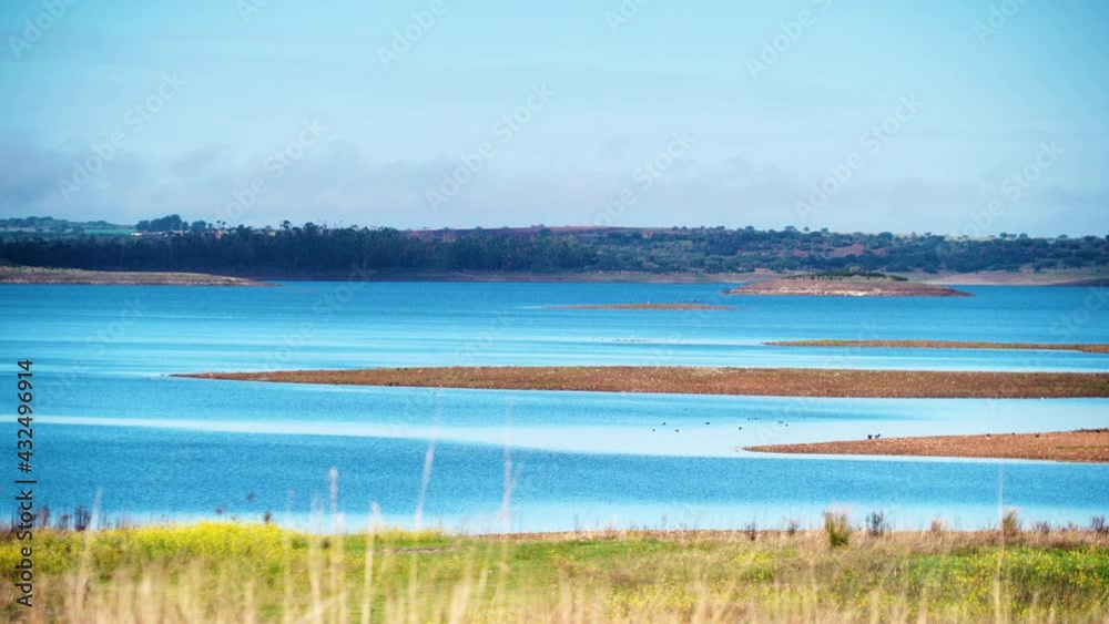 View of Alqueva Dam artificial lake at Luz village, Alentejo tourist destination region, district of Evora, Portugal Europe. View of Alqueva Dam artificial lake at Luz village, Alentejo tourist destination region, district of Evora, Portugal Europe.