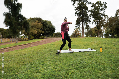 Curvy woman doing workout boxing routine outdoor at city park - Focus on face