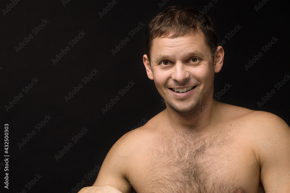 Handsome man on the black background. Muscular and athletic. Man portrait. Male model in studio