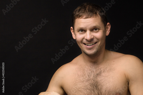 Handsome man on the black background. Muscular and athletic. Man portrait. Male model in studio	