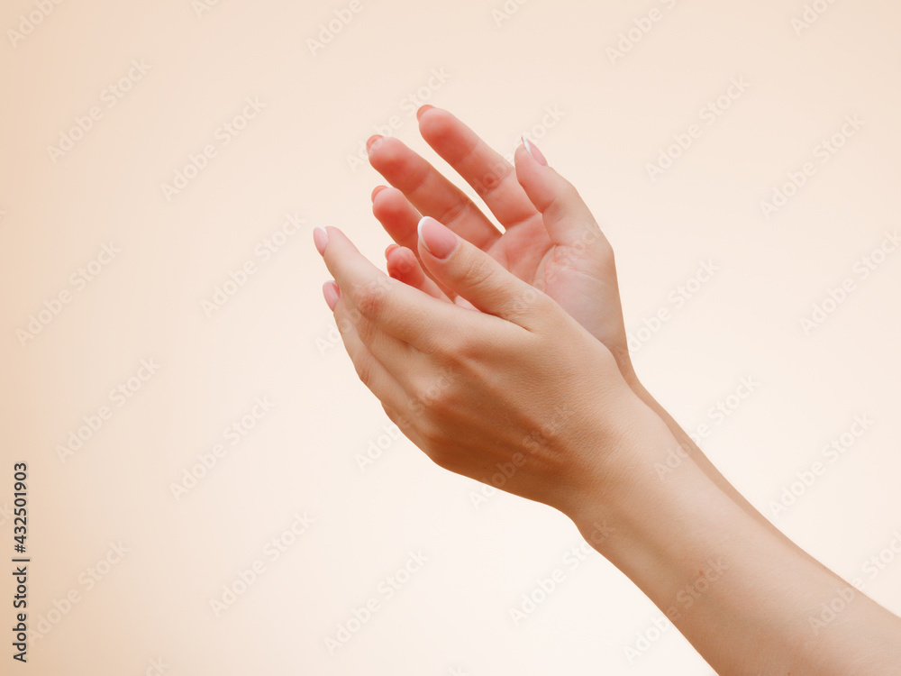 Closeup image of beautiful woman's hands with light pink French manicure on the nails . Skin care for hands, manicure and beauty treatment . Elegant and graceful hands with slender graceful fingers Closeup image of beautiful woman's hands with light pink French manicure on the nails . Skin care for hands, manicure and beauty treatment . Elegant and graceful hands with slender graceful fingers