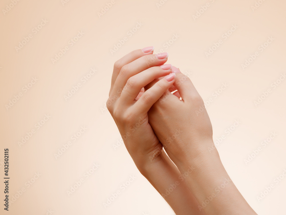 Closeup image of beautiful woman's hands with light pink French manicure on the nails . Skin care for hands, manicure and beauty treatment . Elegant and graceful hands with slender graceful fingers Closeup image of beautiful woman's hands with light pink French manicure on the nails . Skin care for hands, manicure and beauty treatment . Elegant and graceful hands with slender graceful fingers