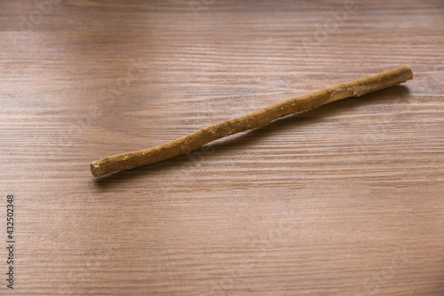 The miswak, miswaak, siwak, sewak, Arabic is a teeth cleaning twig made from the Salvadora persica tree. Miswak on wooden background. photo