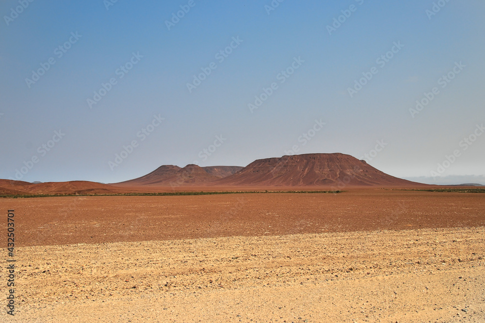 red mountain in a desertic landscape, blue sky, african landscape