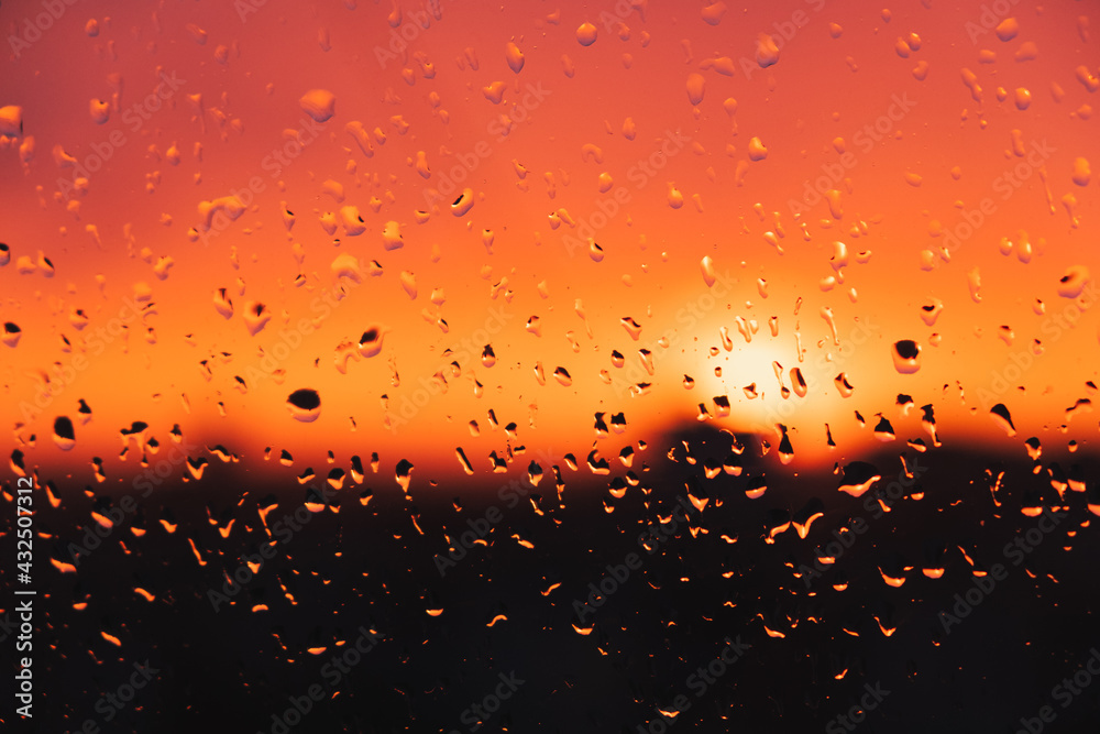 Drops of rain water on the window against the evening sky. Raindrops on the glass, sunset, weather related image