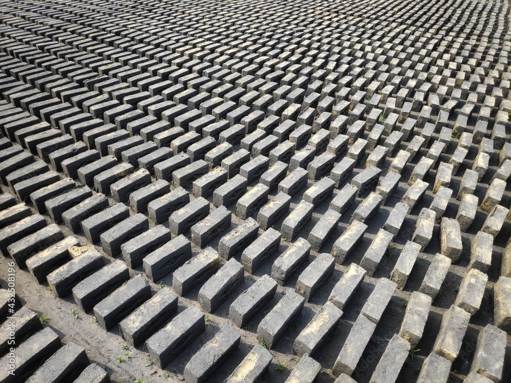 Fototapeta premium Red bricks on pallets, a warehouse for storing building materials. Brick Manufacturing factory located in rural India