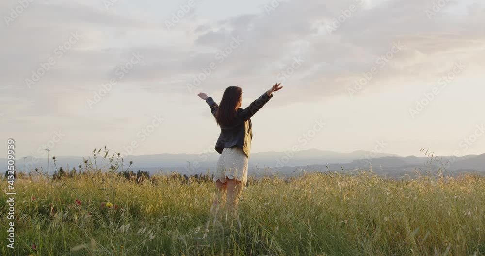 Giovane ragazza con giacca di pelle nero e pantaloncini bianchi cammina in una collina in campagna Giovane ragazza con giacca di pelle nero e pantaloncini bianchi cammina in una collina in campagna