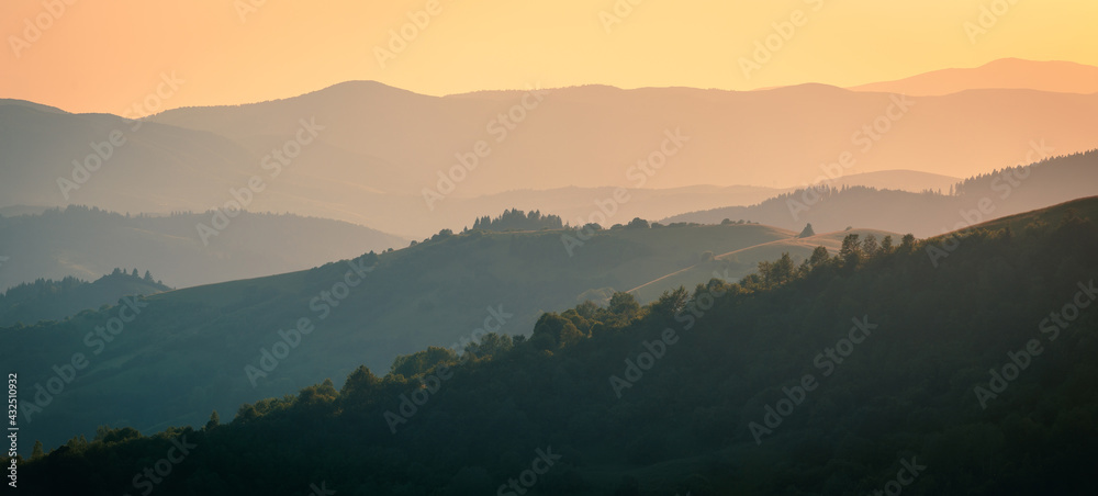 The ridgeline of Carpathian mountains in dusk sunlight. Wide-angle landscape.