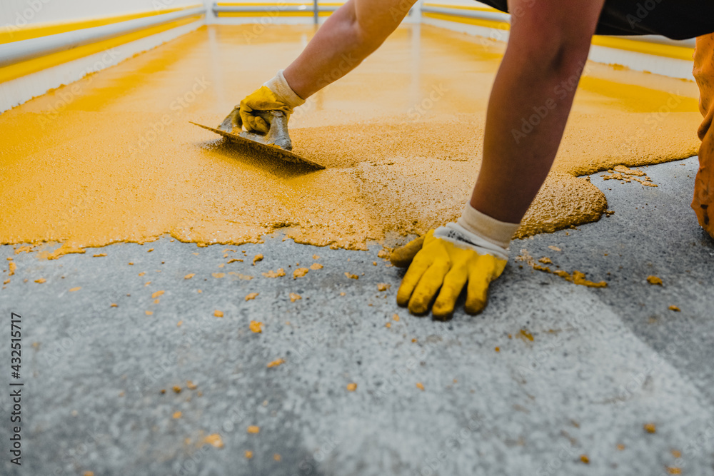 Foto Stock Worker applying epoxy and polyurethane flooring system