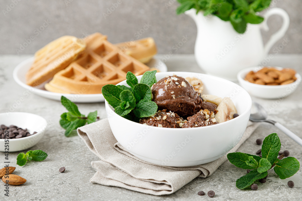 Chocolate and banana fruit ice cream with almond nuts served in bowl