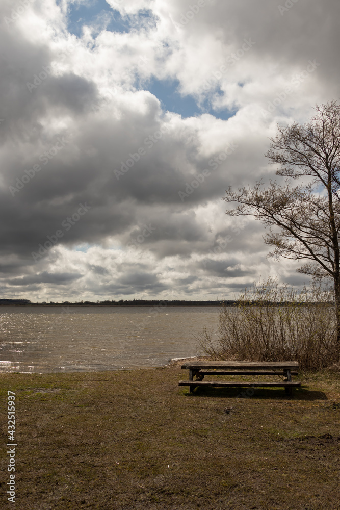 View of the shore of Lake Durbe with a tourist picnic lounge wooden table in the hall.