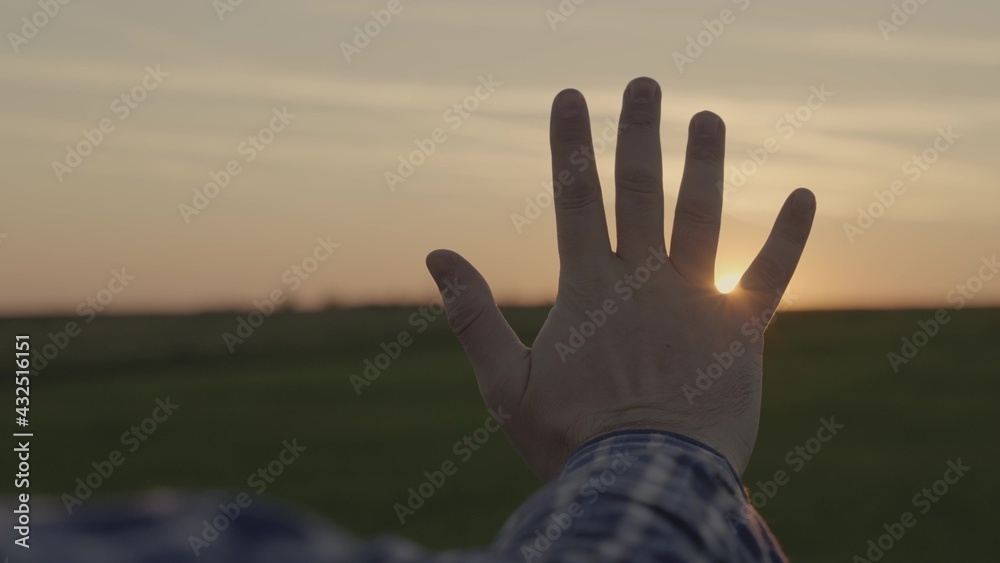 Happy man's hand at sunset. Sunset between the hands of a man. Happy man with dreamily stretches out his hand to the sun. Dream hand to the sun. happy family concept