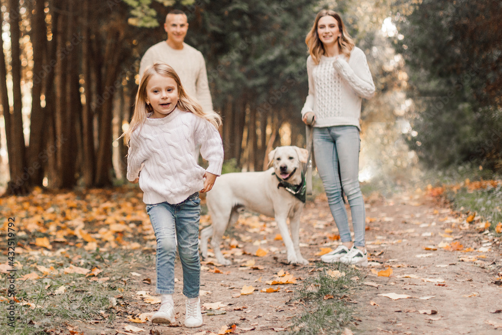 Happy beautiful family with dog labrador is having fun together walking the in park. Happy beautiful family with dog labrador is having fun together walking the in park.