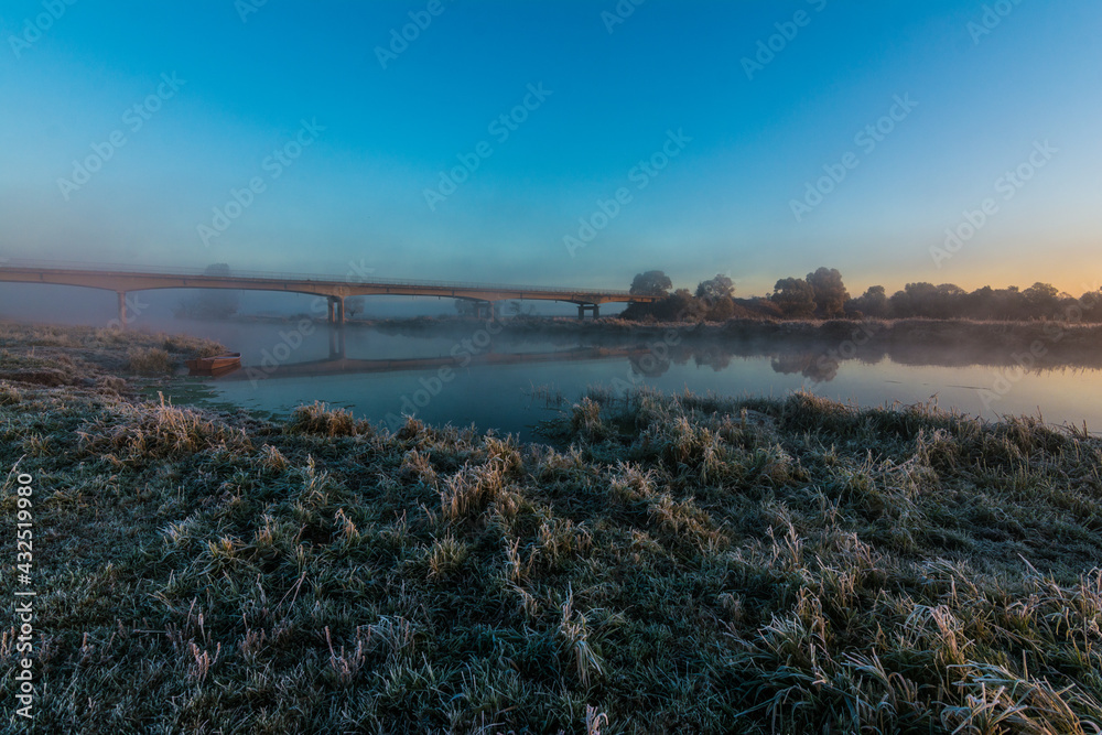 Obraz premium bridge over the Narew river during sunrise