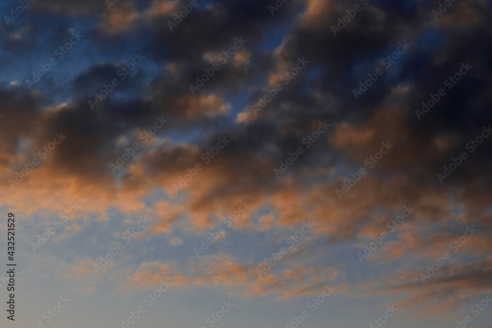 Heavenly landscape background with the texture of clouds at sunset. Beautiful morning sky in blue and orange colors. 