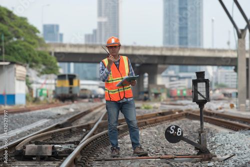 engineer standing and using radio communication on railway with inspection. construction worker on railways. Engineer work on railway.rail,engineer,Infrastructure