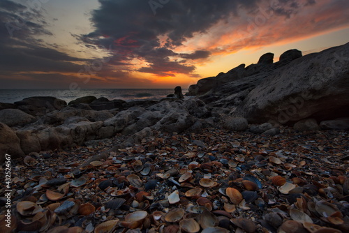 Fototapeta Naklejka Na Ścianę i Meble -  Russia. Dagestan. Dawn on the seashell-strewn rocky shore of the Caspian Sea near the city embankment of Makhachkala.