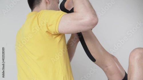 A male masseur stretches a fused tendon on a woman's leg. photo