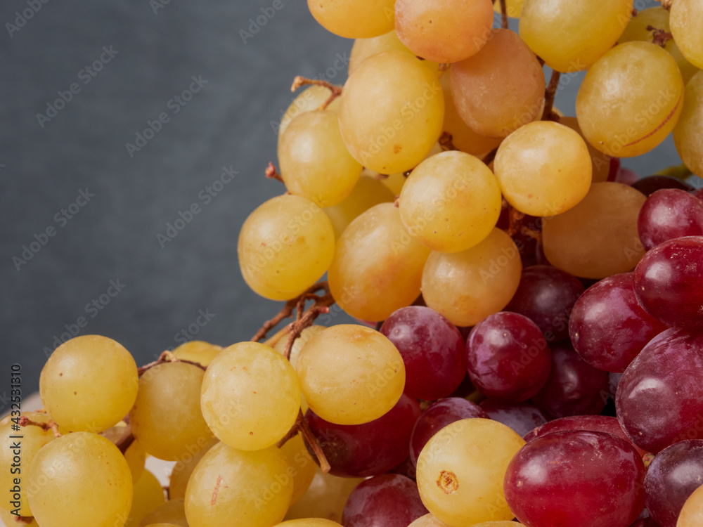 fresh ripe red grapes on a wood texture surface. Ancient style, beautiful background with a branch of blue grapes. Red grape. Dark grapes fresh ripe red grapes on a wood texture surface. Ancient style, beautiful background with a branch of blue grapes. Red grape. Dark grapes