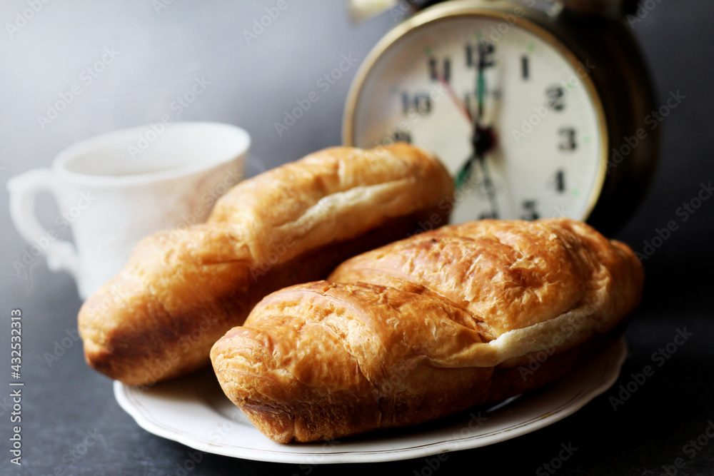 Cappuccino and croissants, alarm clock on black background Cappuccino and croissants, alarm clock on black background