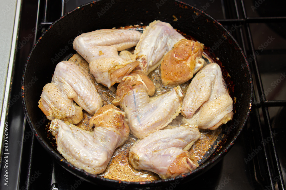 Fry chicken wings in a pan. Home cooking. Cooking chicken meat Fry chicken wings in a pan. Home cooking. Cooking chicken meat