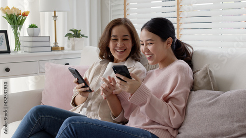 Attractive beautiful asian family sit sofa couch living room enjoy urban life joyful promotion discount shop buy health care insurance online quarantine activity isolate omnichannel experience at home