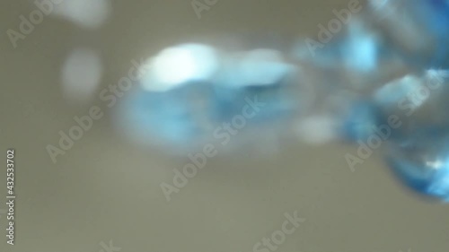 Clear and clear water is poured into a glass cup. bottom view. Water pours