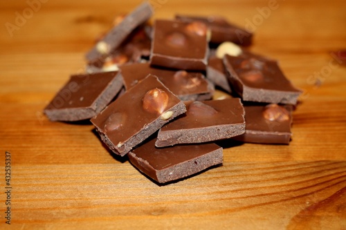 Wallpaper Mural Slices of brown milk chocolate, with nuts, on a wooden table. Torontodigital.ca