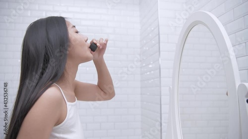 Health concept of 4k Resolution. Young Asian woman gargling in the bathroom.