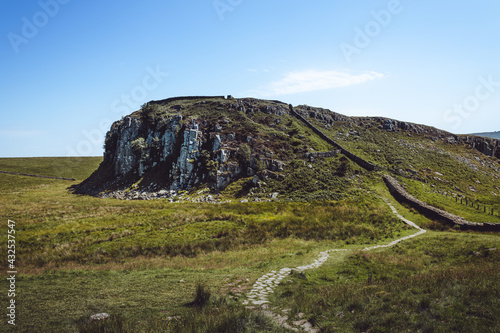 Northumberland UK: Hadrians Wall built on tall cliffs (Roman Wall) on a sunny summer day in English countryside photo