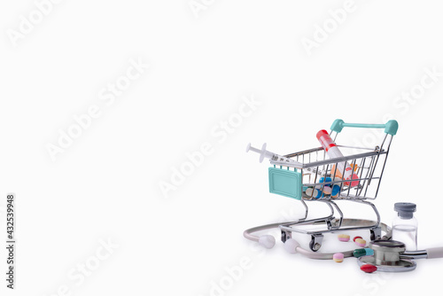 scattered variety pills, drugs, stethoscope, vaccine, syringe and empty shopping trolley cart on white or isolated background. pharmacy shopping concept,copy space for text. © chartphoto