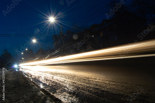night photo of blurred warm light from car headlights along the road