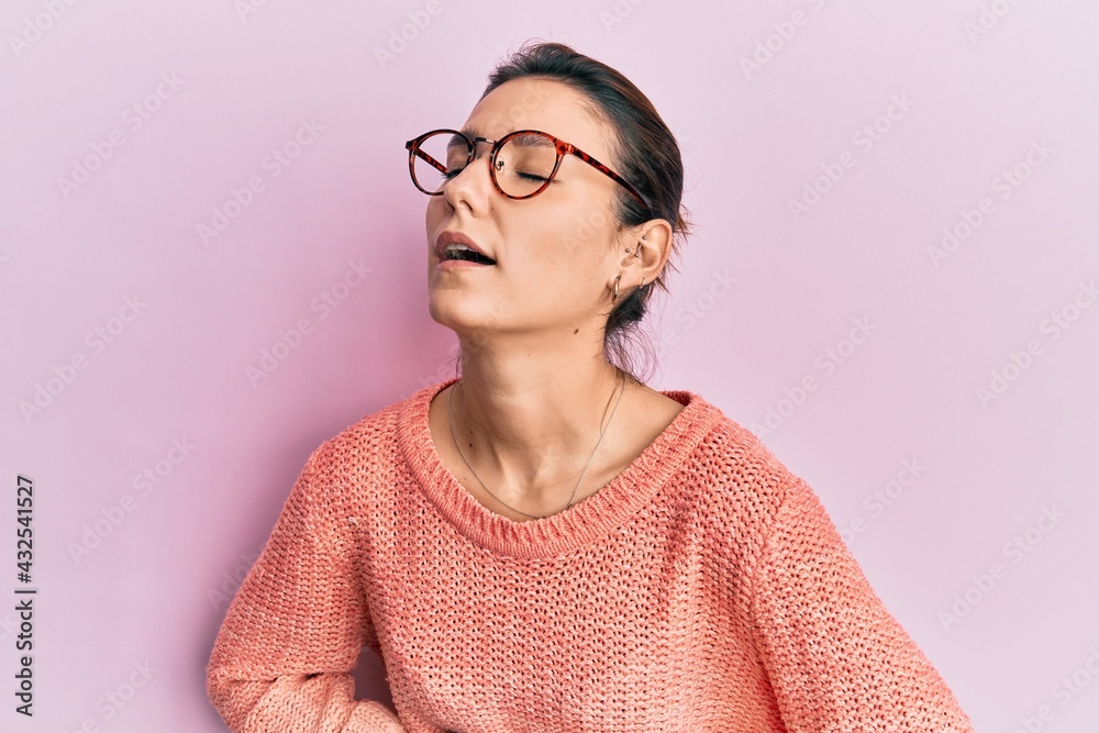 Young caucasian woman wearing casual clothes and glasses with hand on stomach because nausea, painful disease feeling unwell. ache concept.