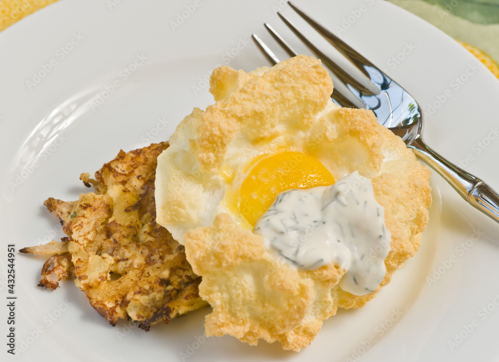 top view, close up of baked egg over a fried crusted crab meat, on a round, white plate top view, close up of baked egg over a fried crusted crab meat, on a round, white plate