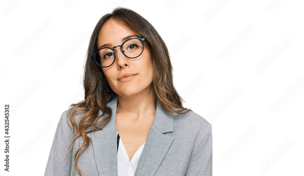 Young brunette woman wearing business clothes relaxed with serious expression on face. simple and natural looking at the camera. Young brunette woman wearing business clothes relaxed with serious expression on face. simple and natural looking at the camera.
