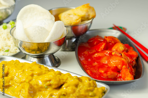 Chinese set,  chicken curry, sweet and sour chicken served with egg fried rice, vegetable spring rolls, and prawn crackers photo